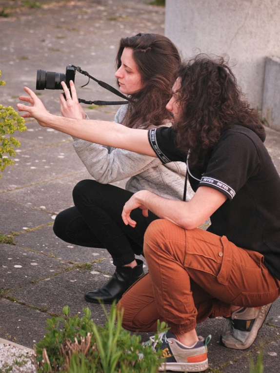 Professeur avec son élève tenant un appareil photo, dans le cadre d'un cours particulier pour apprendre la photographie.