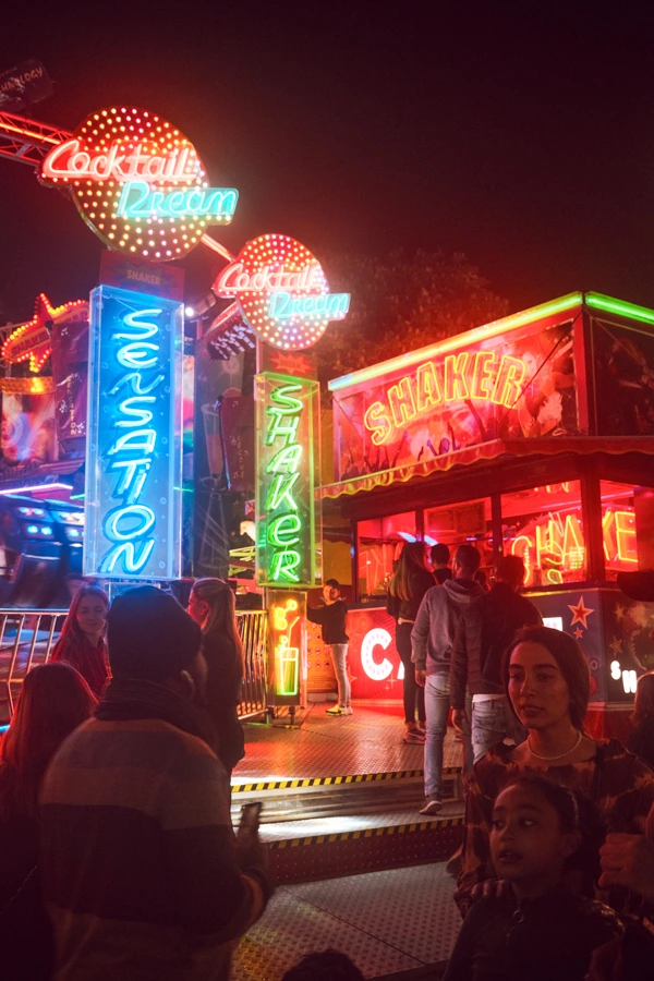 Photo de nuit du manège "Shaker" lors de la fête foraine de Nantes, avec une foule de personnes, par un photographe pro.
